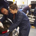 Teacher Helping Student Training To Be Car Mechanics